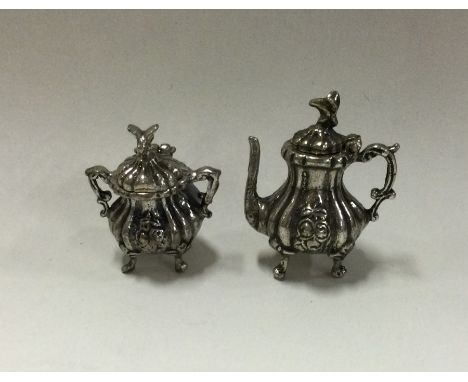 A heavy miniature cast silver teapot together with matching bowl. Approx. 29 grams. Est. £20 - £30.