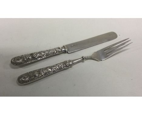 A cast Chinese silver two piece christening set decorated with dragons. Approx. 39 grams. Est. £30 - £40.