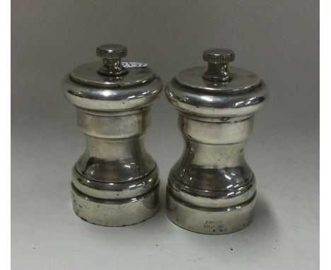 A pair of modern silver pepper grinders. Marked Sterling. Approx. 180 grams. Est. £45 - £55.