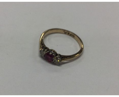 A small ruby and diamond three stone ring in 18 carat mount. Approx. 2.1 grams. Est. £60 - £80.