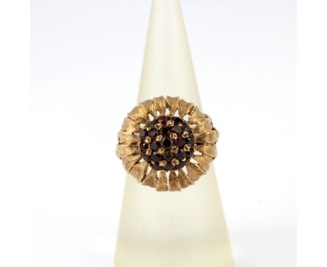 A 9ct yellow gold flower shaped ring set with garnets, UK ring size L. Gross weight approx. 5.8gr.&nbsp;