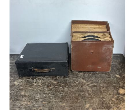 AN antique portable wind up gramophone with a collection of 78 RPM records.