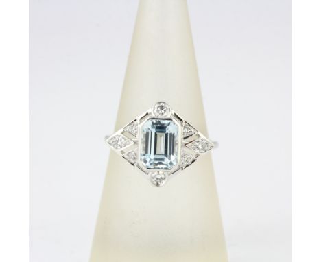 An Art Deco style 950 platinum ring set with an emerald cut aquamarine and brilliant cut diamonds, UK ring size N.5.