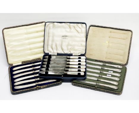 A cased set Mappin and Webb silver handled butter knives together with a further set of silver handled knives and a set of mo