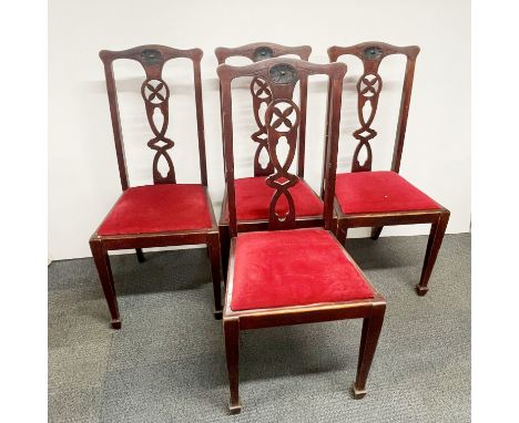 A set of four Art Nouveau dining chairs with carved mahogany backs and red upholstery, H. 102cm.