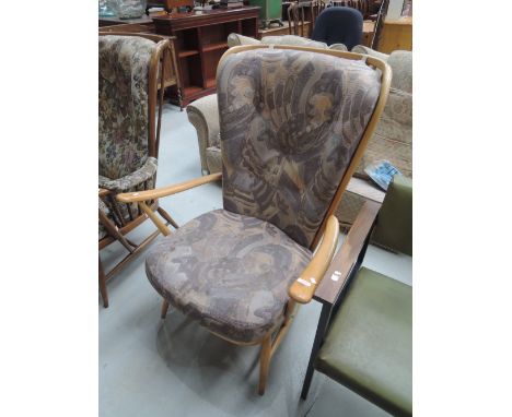 An Ercol armchair in light stainFrame slightly loose, paint spots to one arm. few light scratches and chips. Cushions in need