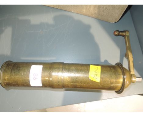 A vintage brass Middle Eastern coffee grinder, of mechanical form having hieroglyphic decoration