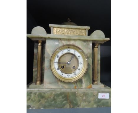 A late 19th/early 20lth century onyx mantel clock of architectural form, having circular Roman numeral dial, flanked by brass