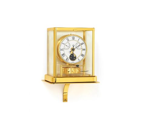 ATMOS MIT WANDKONSOLE. Jaeger LeCoultre. Technik: Glas, vergoldetes Messing u.a. Beschreibung: Verglastes Gehäuse. Weißes Lac