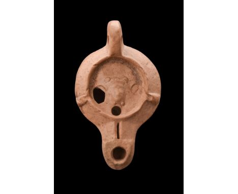 Ca. 100-200 AD. A terracotta oil lamp with a globular body with a spout with a vent hole and flaring finial. Circular discus 
