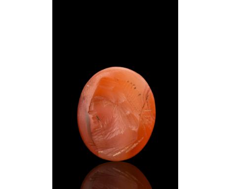 Ca. 100-300 AD. An oval-shaped carnelian intaglio engraved with a striking left-facing portrait of Jupiter, the ruler of the 