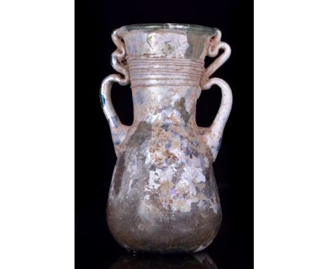 Ca. 100-200 AD. A beautiful blown flask with an ovoid-shaped body, funnel-shaped neck with ribbed horizontal decoration, and 