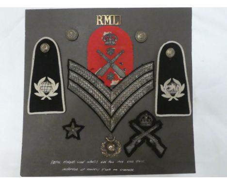 A display of Royal Marine Light Infantry badges including brass title, cap badge, pair of embroidered cloth eppaulettes, chev