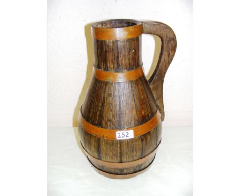 A Georgian style oak and copper bound ale jug, marked to the top V-Radford Maker, measuring 14" tall. CONDITION REPORT: Good 