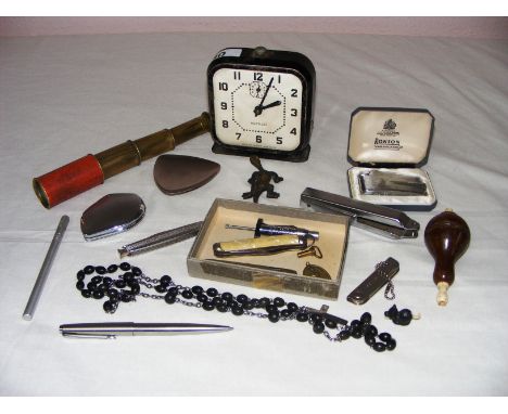 A vintage American Hustler alarm clock, a miniature telescope, pen knives, lighter etc. 