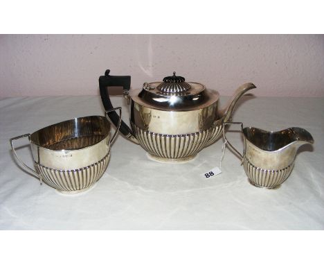 A sterling silver three piece tea service in a semi gadrooned pattern hallmarked for Birmingham 1938 by William Vale & Sons, 