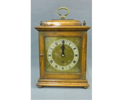 Oak cased mantle clock with caddy top, silvered chapter ring with Arabic numerals and an Empire brass movement, stands on fou