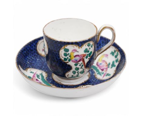 18th century Worcester coffee cup and saucer decorated with panels of birds and flowers in Kakiemon style on a blue ground