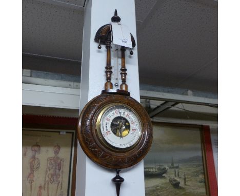An early C20th enamel mounted barometer walnut case with classical urn pediment