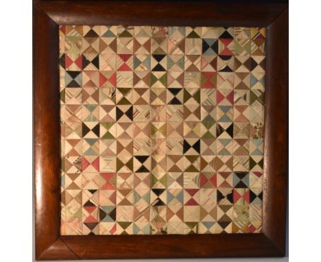 A 19th century folk art textile sampler, brightly worked in a patchwork of varying lozenges, 41cm x 42.5cm, rosewood frame