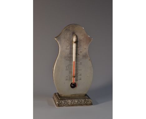 An early 20th century Swedish silver desk thermometer, engraved scale, rectangular base, pierced with borders of stylised lea