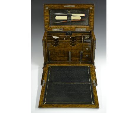 A Victorian oak stationery cabinet, hinged top and fall front enclosing a folding tooled and gilt leather writing surface, an