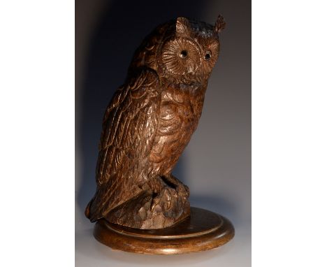 An early 20th century oak novelty lamp or night light, carved as an owl, the eyes illuminated from within, circular base, 29c