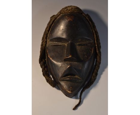 Tribal Art - an African hardwood mask, domed forehead, angular features, matted cord hair, 21cm long, Dan, Ivory Coast 