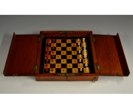 A Victorian mahogany travelling chess set, hinged cover enclosing a folding board and bone pieces, 20.5cm wide, c. 1880