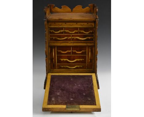 A 19th century gentleman's specimen wood desk-top cabinet, shaped three-quarter gallery above a panelled fall front enclosing