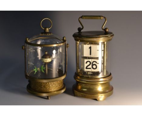 An Ever Ready Chronos ticket flip clock, brass case with clear glass cylinder, swing carrying handle, 13cm high; an automaton