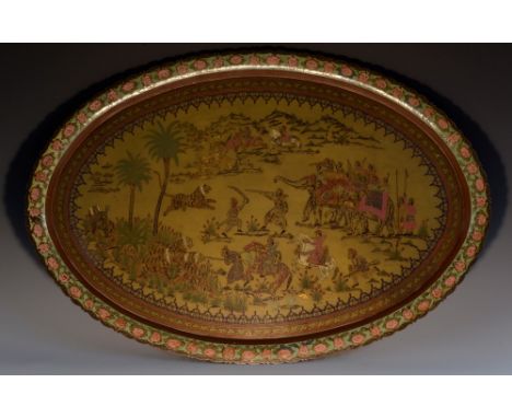 An Indian brass and enamel shaped oval serving tray, chased and decorated in polychrome with a tiger hunt,  76.5cm wide, insc
