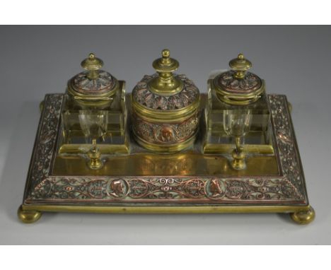 A Victorian Renaissance Revival brass and copper rectangular standish, central cylindrical wafer box flanked by a pair of squ