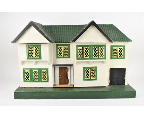 A Vintage Tri-ang-type doll's house, in the Tudor style with tin-plate windows, opening in two sections revealing a furnished