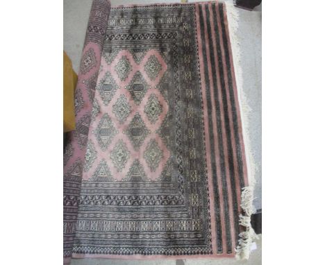 A hand woven Pakistan rug with elephant gulls on a light pink ground, multiguard borders and tasselled ends 230cm x 160cm 