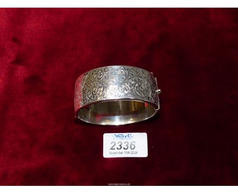 An antique Silver cuff Bangle with clasp, hinge and chain, one half with decorative engraving, Birmingham 1946, makers Smith 