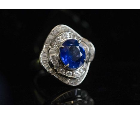 A FINE SAPPHIRE AND DIAMOND CLUSTER RING, the oval shaped mixed cut sapphire of fine bright blue colour, weighing 3.93 carats