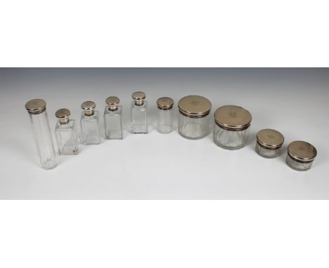 Ten matching clear glass dressing table jars and bottles, with silver screw tops  London, F &amp; Co. Ltd, each with engraved