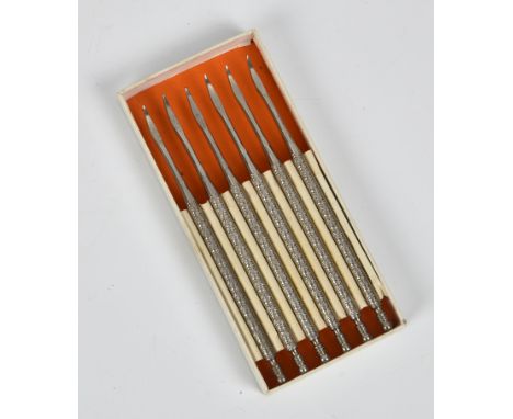 A boxed set of six silver plated tooth picks  with tooled handles.  