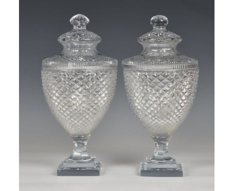 A good pair of Georgian style cut glass covered urns  20th century, the bodies with diamond cutting, on panel cut waisted ste