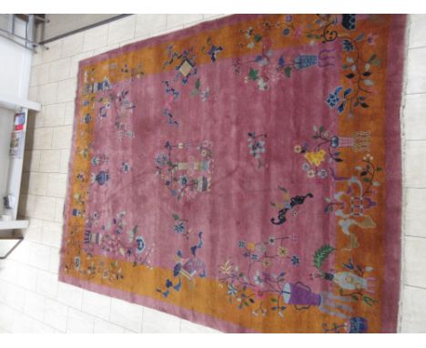 An early 20th Century Chinese Carpet with gold border, decorated vases of flowers on a mauve ground, 11ft 8in x 8ft