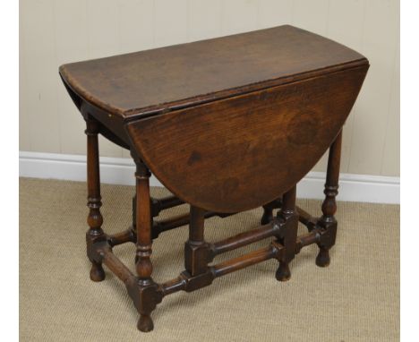 An 18th Century oak oval Gate-leg Table on gun barrel turned and square legs united by turned and square stretchers, 2ft 10in