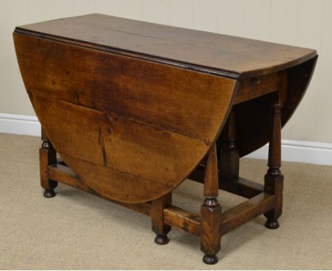 An 18th Century oak oval Gate-leg Table, fitted single drawer on baluster turned and square legs united by square stretchers,