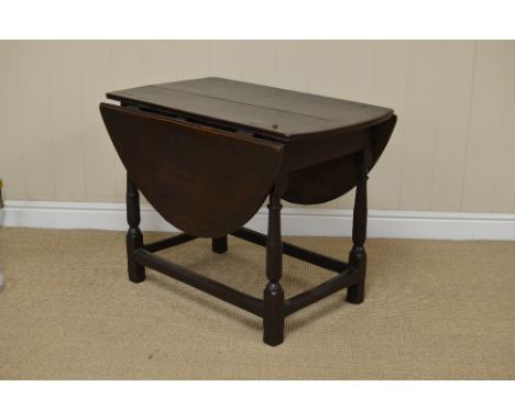 A small 17th Century oak oval Gate-leg Table with iron hinges on primitive turned and square legs united by square stretchers