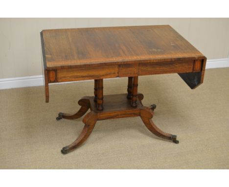 A late Regency rosewood and satinwood-crossbanded Sofa Table, the top with canted corners, the frieze with two frieze drawers