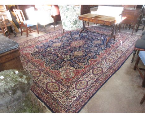 A bordered Tabriz Carpet with floral design on a blue ground, 13ft 9in x 9ft 11in