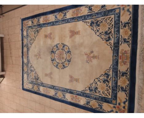 A Chinese Carpet with blue border, stylised floral motifs on a cream ground, 12ft 4in x 8ft 5in