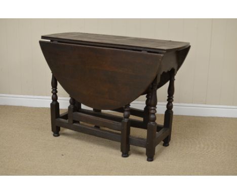 A 17th Century oak oval Gate-leg Table fitted single drawer above cupids bow frieze on baluster turned and square legs united