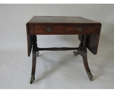 A Regency mahogany and rosewood crossbanded Sofa Table, each side with one short and one dummy drawer on four twisted columns