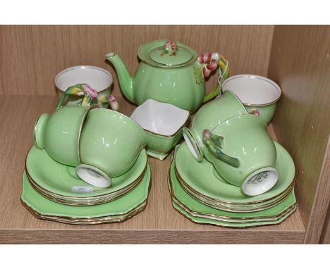 A ROYAL WINTON TEA SERVICE with florally moulded handles comprising a tea pot, a squared sugar bowl (chipped rim), six tea cu